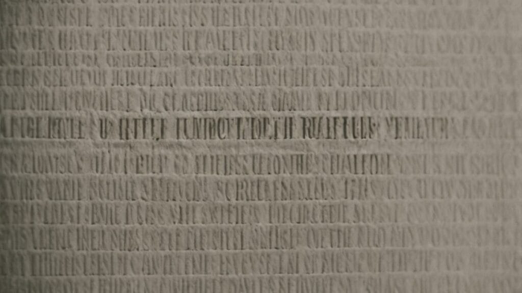 A close up of a grey wall with Hebrews written on it.
